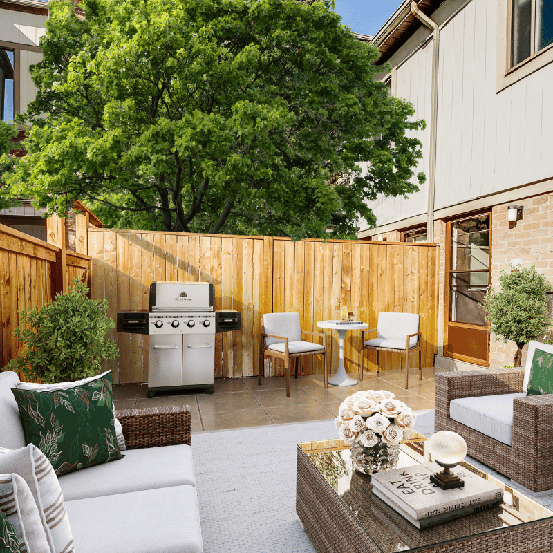 Staged fenced-in patio with BBQ and lounge space.